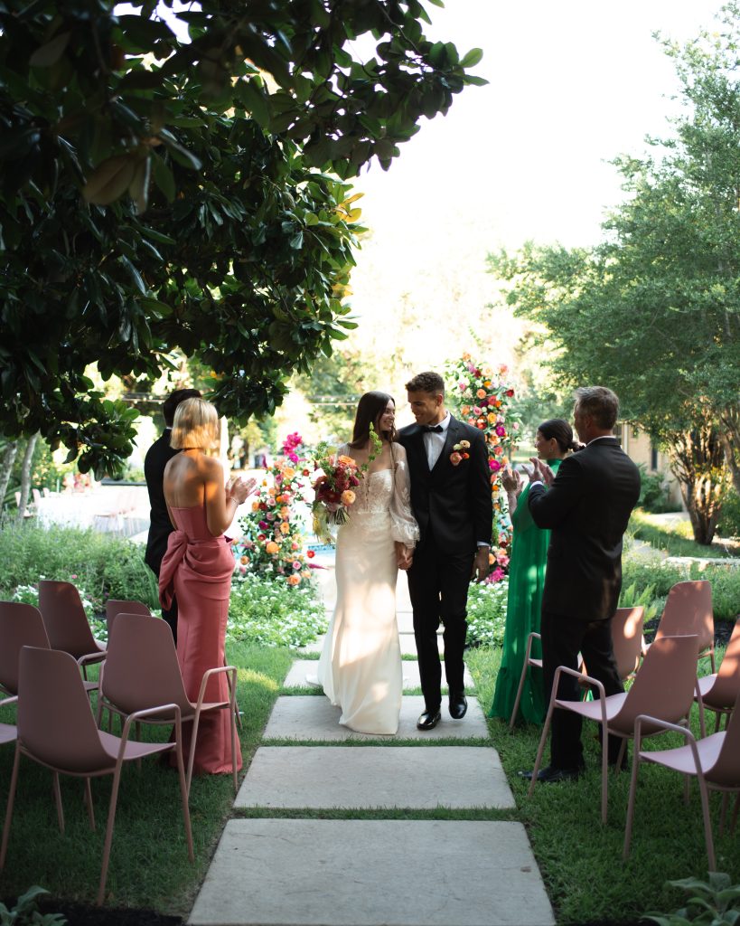 Bride and Groom walk down aisle at intimate courtyard wedding